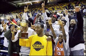 Libbey s William Buford hoists the City League championship trophy following the Cowboys  victory over St. John s at Savage Hall last week.
