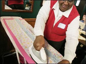 nbrw linus21p     2/16/2008         The Blade/Herral Long    Carolyn McIntosh of toledo irons quilt  Please get fotos during Make a Blanket Day for Project Linus, Toledo/Lucas County Chapter, from 10 a.m. to 3 p.m. at Charlie's Pizza in Saxon Square. Want fotos of people making the blankets that will be given to the Lucas County Children's Services for distribution to foster children. Some people will be sewing blankets, others will be doing their work without the aid of machines. Sponsors are donating machines, scissors, space, money, etc., for blankets. About 40 were made during Blanket Day last year, and the chapter hopes to make more this year.