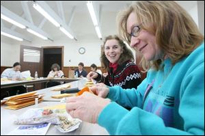 Claudia Anderson, left, and beverly Monahan, right, sort and bag seeds in preparation for the annual seed exchange at Toledo Botanical Gardens.
