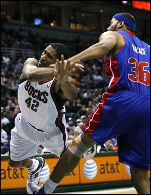 Milwaukee Bucks guard Charlie Bell goes flying after being fouled by Detroit Pistons forward Rasheed Wallace, right.