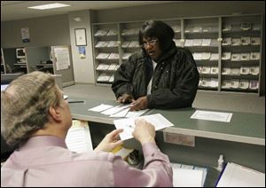 Tom Hojnacki handles questions from taxpayer Virgaie Washington at the IRS offices in downtown Toledo.