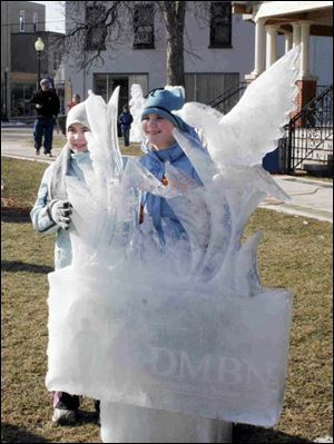 nbrn iceharvest 28P     2/24r/2008         The Blade/Herral Long  Sonya 12 and Maggie Roehrig of  Monroe  enjoy  bird   ice sculpture   get photos of ice sculptures in Downtown Monroe.   note the sun was starting to rot the ice an many were  falling or were being pushed over.