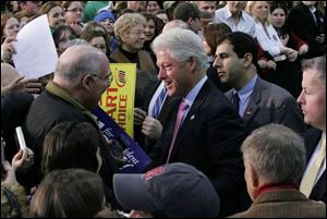 Former President Bill Clinton greets people during a rally at the University of Findlay's Croy Physical Education Center.