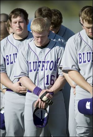 Sophomore A.J. Ramthum (16) and his teammates take a moment to mark the one-year anniversary of the bus crash that killed five Bluffton baseball players on March 2, 2007.