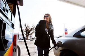 Kim Giarmo of LaSalle, Mich., buys gas for $3.299 on Alexis Road. She says her husband commutes to Detroit every day.
