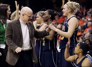 Outgoing Toledo coach Mark Ehlen celebrates with his bench as the Rockets beat Ball State in the quarterfinals of the Mid-American Conference basketball tournament yesterday in Cleveland. UT lost to the Cardinals by 27 points three weeks ago.
