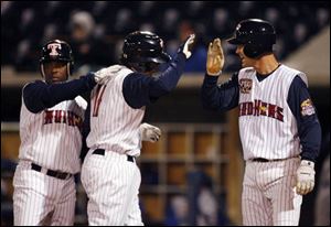 Timo Perez, left, and Derek Wathan, right, congratulate Jeff Larish after the Mud Hens first baseman hit his first home run at the Triple-A level. Larish had two hits, Perez had one and Wathan collected three as Toledo scored nine runs on 12 hits against Durham at Fifth Third Field last night.