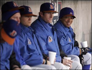 Durham relief pitcher Calvin Medlock, far right, chats with teammates during their game last night against the Mud Hens. Medlock is the only African-American player on the Bulls' roster.