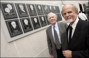 Medical Mission Hall of Fame president Larry Conway, left, and 2005 inductee Dr. Glenn Geelhoed stand beside the honorees' plaques in the Center for Creative Education at the University of Toledo Health Science Campus.