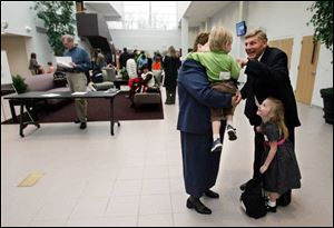 Loren Peterson, at right, greets his wife Ruth and their grandchildren, Jackson, left, and Madelyn, right, in Westgate Chapel's lobby, which was added to the church in 2006.