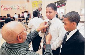Ronald Thompson, ex-CEO of Midwest Stamping and Manufacturing, fixes Kemon Thorton's tie. Alontay Gould watches.