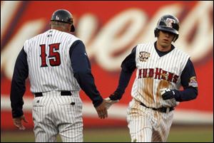 Mud Hens manager Larry Parrish congratulates Jeff Larish as he rounds third base after hitting a home run in the first inning. Larish hit another home run in the eighth inning. Toledo starter Macay McBride had to leave last night's game in the first inning after consulting with trainer Matt Rankin.