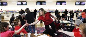 Judy Lou of the Northwood Jewelers team from Toledo gets high fives from her teammates at Interstate Lanes in Rossford. 