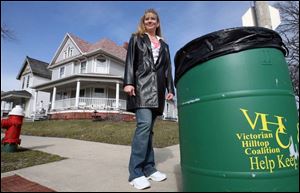 East Toledo community activist Gail Wahl, left, says placing large trash cans like this one on local streets has helped keep hundreds of pounds of trash off the streets and lawns of the east side. A dozen of the 55-gallon cans were donated by Sunbeam Products, an east-side soap and detergents manufacturer. Miss Wahl founded the Victorian Hilltop Coalition, which maintains the cleanup.