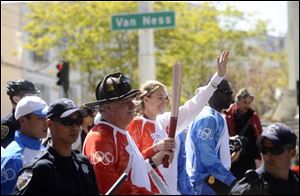 Kerri Walsh, a former Olympic volleyball gold medalist, carries the Olympic torch in San Francisco on Wednesday. The Olympic torch was rerouted away from thousands of demonstrators and spectators who crowded the city's waterfront to witness the flame's symbolic journey to the Beijing Games. 