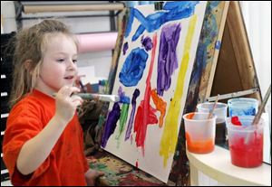 Grace Ulch, 5, of Oregon, left, works on her masterpiece 'The Wave at Kalahari' at the child care center at Owens Community College in Perrysburg Township. 