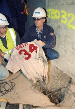 Frank Gramarossa, right, project executive for the new Yankee Stadium, removes a Red Sox jersey from the ground.