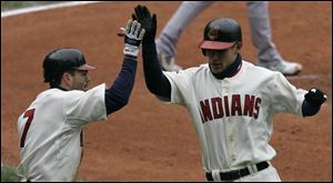 Jamey Carroll, left, greets Grady Sizemore at home after they each scored on a single by Travis Hafner in the third inning.
