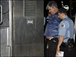 Donald Wells of Metamora, Mich., identified by hospital spokesman Sean Howard as the driver of a truck that was involved in a rush hour accident. is taken into police custody on Friday in Chicago. The 64-year-old truck driver has been cited for negligent driving after ramming his semitrailer into a Chicago Transit Authority train station. (ASSOCIATED PRESS)
<br>
<img src=http://www.toledoblade.com/graphics/icons/video.gif> <b><font color=red>AP VIDEO</b></font color=red>: <a href=" http://video.ap.org/vws/search/aspx/ap.aspx?t=s1179980883147&p=ENAPus_ENAPus&g=0428dvs_il_truck_accident&f=OHTOL"target="_blank "><b>Driver who slammed into train station cited</b></a>