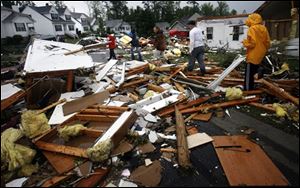 Residents of Burnett's Mill walk through the neighborhood to look at damage after a tornado hit Suffolk, Va., Monday.