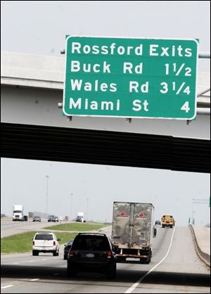 Motorists driving north on I-75 pass the Route 795 exit to Rossford before reaching the first sign pointing the way to the city. This sign on the Route 795 overpass identifies the Buck Road, Wales Road, and Miami exits leading to Rossford. A businessman wants the state to add more signs on I-75 leading to Rossford.