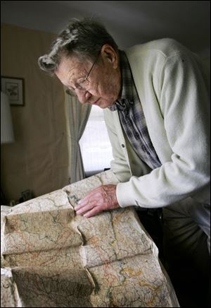 Frank Basler studies a map showing the route he traveled in Europe where he was a tank driver during World War II.