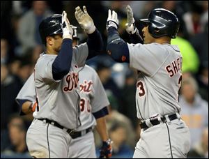 Placido Polanco, left, who had four hits, greets Gary Sheffield after the Tigers DH smashed a homer in the third inning.
