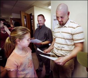 Slug: NBRN bus01p      Date:  04/22/2008        The Blade/Andy Morrison       Location:  Monroe     Caption:  Ken Lambert, left, and Aaron Pierce look at drawings given to them by Alexa Steve, 9, and her sister Lauren Steve, 7, after an awards ceremony honoring the two and others at Monroe Public Schools Board of Education Office, Tuesday, 04/22/2008. The Steve girls were on the bus the two boarded and stopped.      Summary: