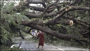 A Myanmar Buddhist Monk makes his way past a fallen tree following a devastating cyclone on Sunday, in Yangon. The death toll from the cyclone has risen to almost 4,000, a Myanmar state radio station has said. 