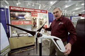 Steve Ash of Sylvania Township, who attended a trade show last month, shows off a wind generator that can produce 500 watts of power. The exhibit was part of the Showcase Sylvania Business Expo at Tom-O-Shanter Sports.

