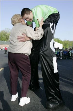 Neil Sauter gets a goodbye hug from his grandmother Eileen, as he sets off on an 830-mile trek across Michigan on stilts.
