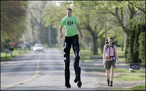 Mr. Sauter walks along Whiteford Center Road in Lambertville, Mich., with his fiancee, Kelly Riley of Hastings. He departed yesterday for an 830-mile trek across Michigan.

