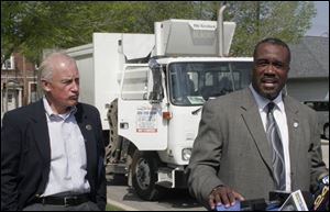 Mayor Carty Finkbeiner, left, and Julian Highsmith, commissioner of solid waste, hold a press conference marking the first day of the city's automated trash pickup program.