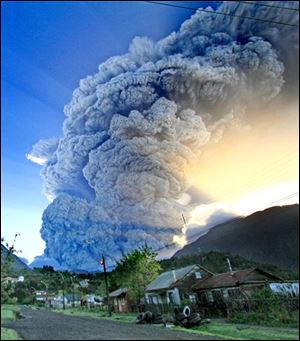 A cloud of smoke and ashes produced by intensified eruption of the Chaiten volcano are seen over Chaiten on Tuesday, in southern Chile. The eruption spewed incandescent material and blated ash some 20 miles (30 kilometers) into the Andean sky, forcing authorities to a complete evacuation of the area. 