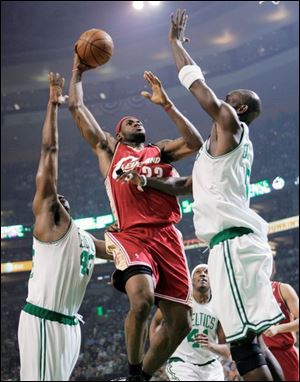 Cleveland's LeBron James shoots between Boston's Kendrick Perkins, left, and Kevin Garnett last night in Boston.