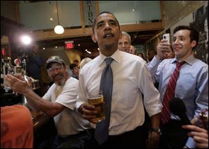 Democratic presidential hopeful, Sen. Barack Obama, D-Ill., holds a glass of beer as he greets people at Raleigh Times bar in Raleigh, N.C., on Tuesday. 