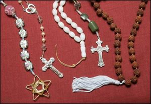 Baha'i prayer beads, left, a Catholic rosary, a Muslim mesbaha, Anglican Protestant beads, and a Hindu mala at the boutique.