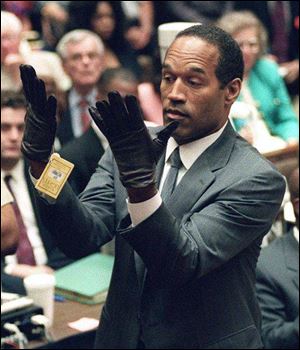 In this June 21, 1995, photo, O.J. Simpson holds his hands up to the jury after putting on a pair of gloves similar to the infamous bloody gloves in his double murder trial in Los Angeles.