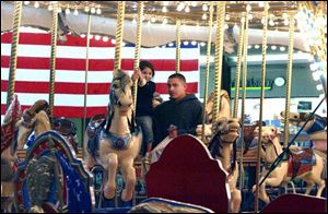 Alyciana Garcia, with her father, Jose Garcia, take a ride on the Southwyck Carousel. The few shoppers and walkers at the mall yesterday seemed indifferent to the city-ordered cleanup of black mold and asbestos there.