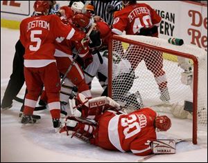 Red Wings goalie Chris Osgood lies in front of his net while teammates scuffle with the Stars  Mike Ribeiro. Osgood apparently poked Ribeiro, and Ribeiro retaliated by slashing Osgood. 
