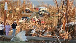 Residents survery the damage from a tornado that ripped through the city of Picher, Oklahoma on Saturday. At least six people were killed as the tornado flattened the northeastern Oklahoma town of Picher before the funnel struck about 15 miles away near Seneca, Mo., and killed at least three, authorities said. 