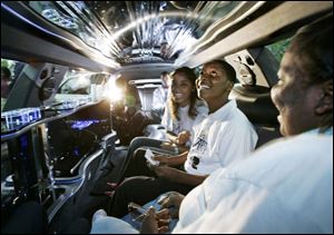 Daryl Long, Jr., checks out the limousine's interior with Angela Lucas, left, executive director of The Kings Kids Academy, and his mother, Ann Kelley, right. 