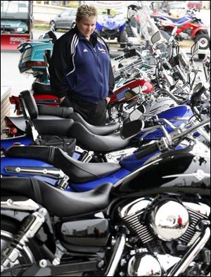 Millbury's Donna Young looks at motor scooters at a motorcycle dealership in Maumee.