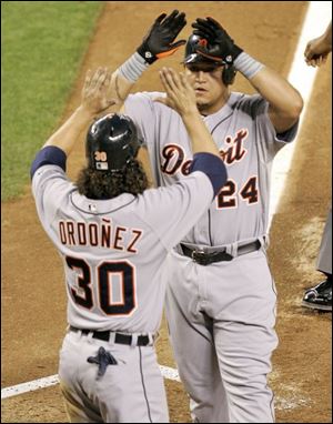 Detroit's Miguel Cabrera, top, high-fives Magglio Ordonez after homering in the third inning against Arizona.