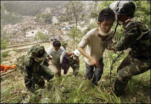 Soldiers help residents as they evacuate to higher ground from the center of earthquake-hit Beichuan County, southwest China's Sichuan province, Saturday, May 17, 2008. Thousands of Chinese earthquake victims fled areas near the epicenter Saturday, fearful of floods from a river blocked by landslides. 