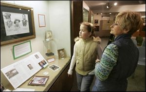 Mackenzie Kegerreis and her grandmother Cheri Weakly view a display at the Monroe County Historical Museum.