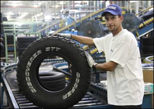 Cooper Tire employee Ron Shepard inspects the Discoverer STT and works in the Finishing department.