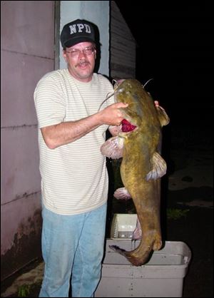 Mike Mainhart of Vienna, Ohio, displays a world line-class flathead of 43 pounds caught and released in Mosquito Lake in northeastern Ohio.