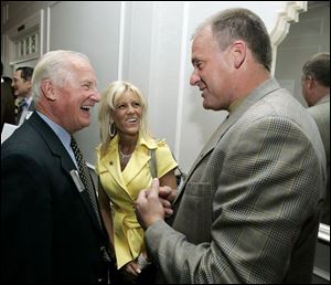 Toledo Mayor Carty Finkbeiner, left, chats with University of Michigan football coach Rich Rodriguez and his wife, Rita, at a gathering of Wolverine supporters at Toledo Country Club.