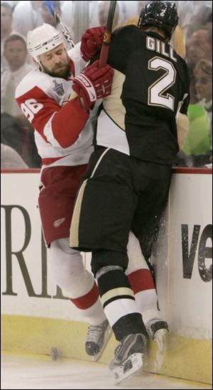 Detroit's Tomas Holmstrom, left, mixes it up with Penguins defenseman Hal Gill for a loose puck in Game 3.